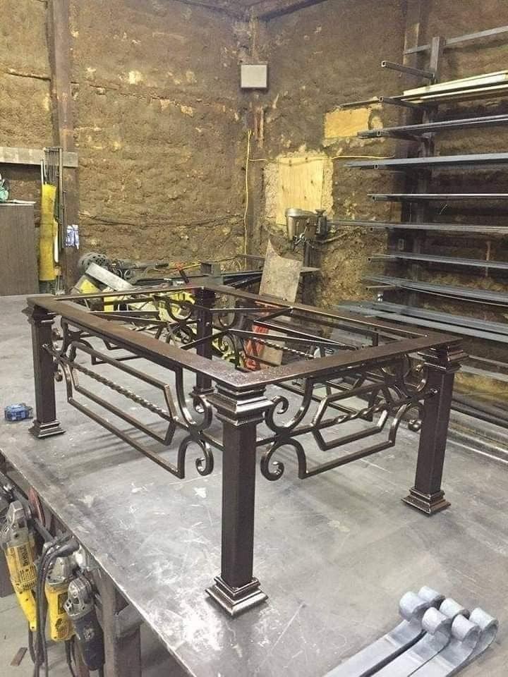 Tafelonderstel in ruw staal met gesmede krullen, op de werkbank in het atelier